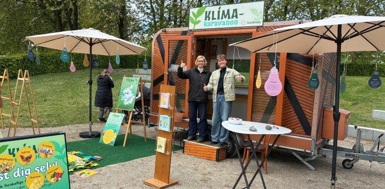 Klimakaravanen vises frem. En lille vogn med aktiviteter foran.